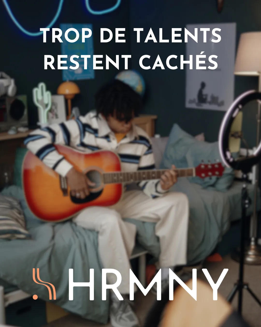 Visuel HRMNY : un guitariste dans sa chambre, flou, texte « Trop de talents restent cachés ».